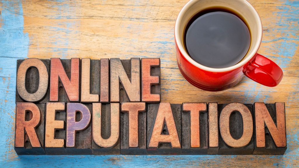  A cup of coffee sits next to woodblock letters that spell 'Online Reputation'.