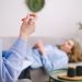 A person lying on a sofa and talking to a therapist.